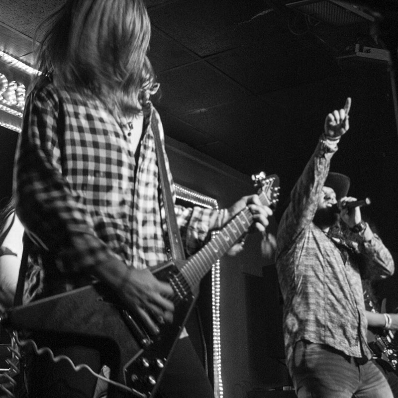 Band playing guitars and singing on stage in Augusta, GA