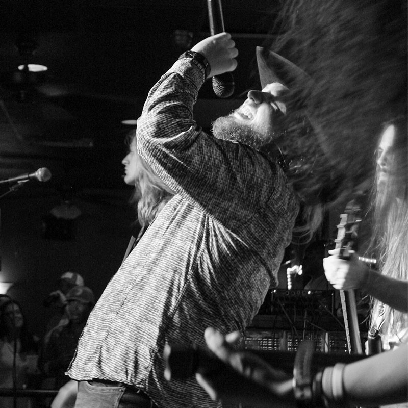 Man playing the guitar and singing on stage in Augusta, GA